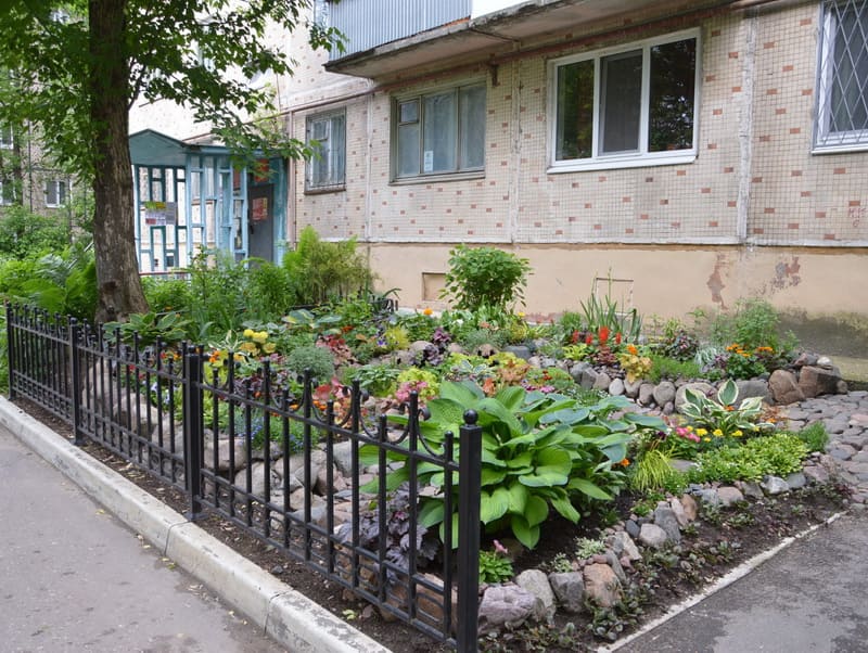 На первом этаже можно обустроить красивую клумбу под окнами